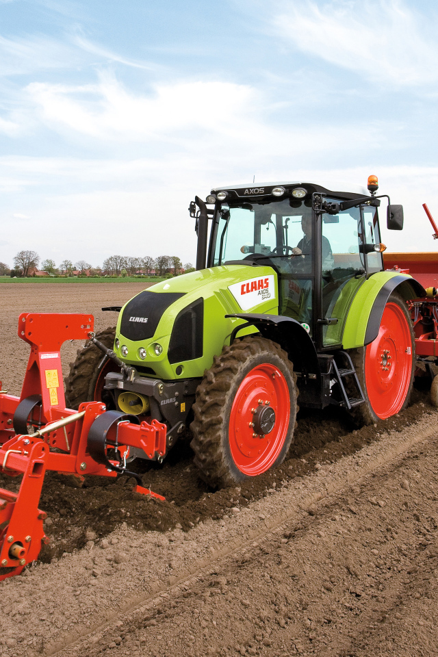 Большой комбайн сеет в поле 