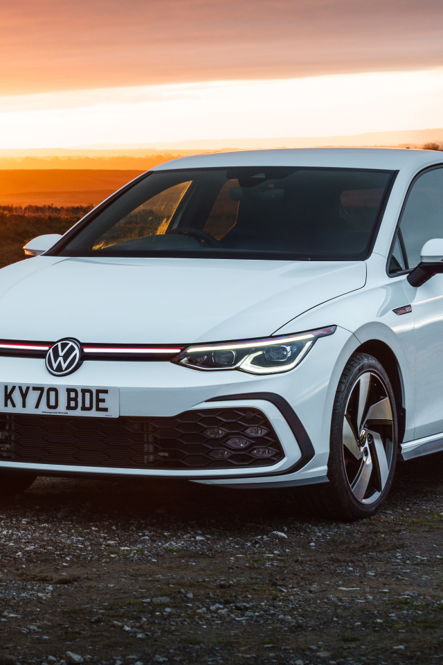 Белый автомобиль Volkswagen Golf GTI 2020 года на закате солнца