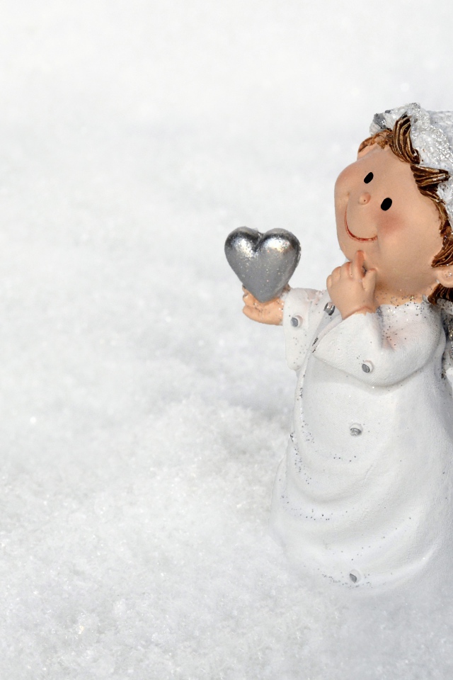 Статуэтка ангела стоит на снегу 