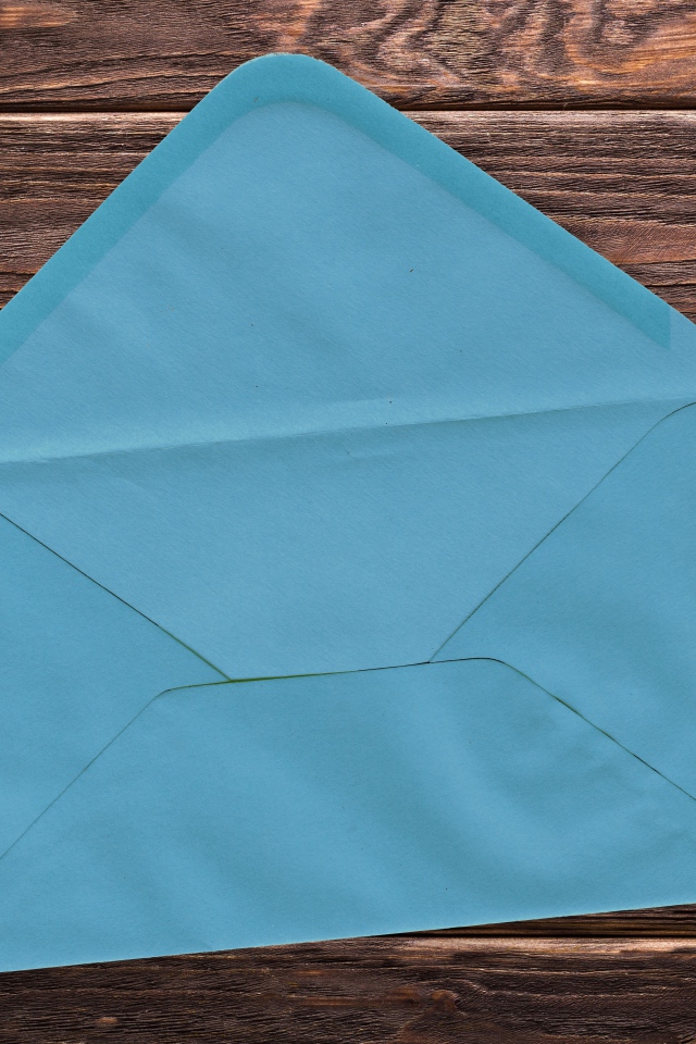 Голубой бумажный конверт на деревянном фоне