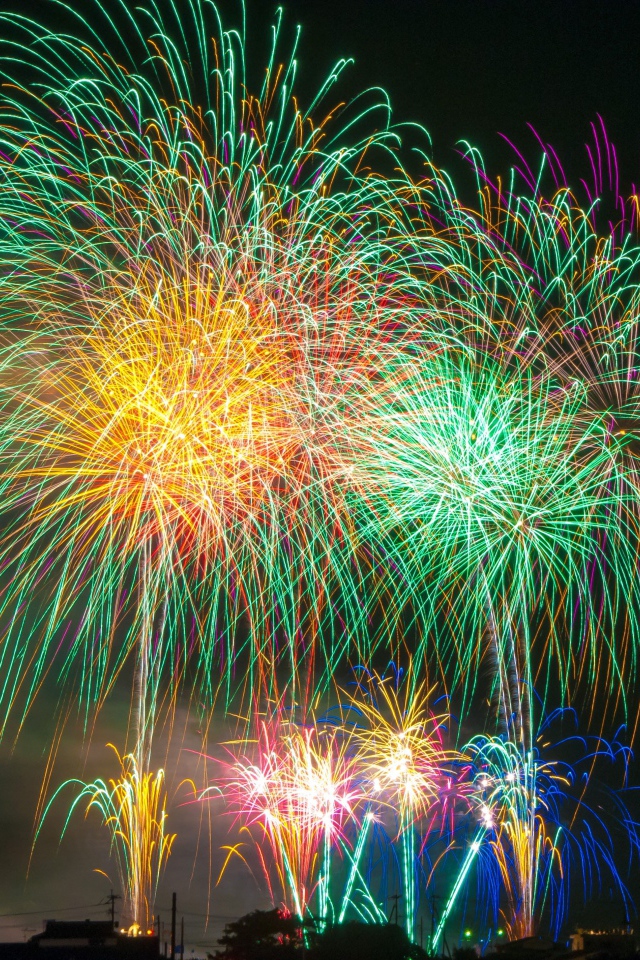 Яркий разноцветный праздничный фейерверк в  небе над городом 