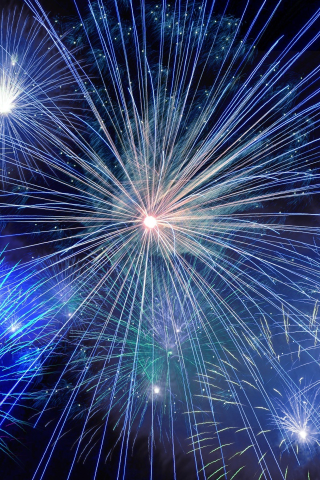 Яркие искры голубого фейерверка в темном небе