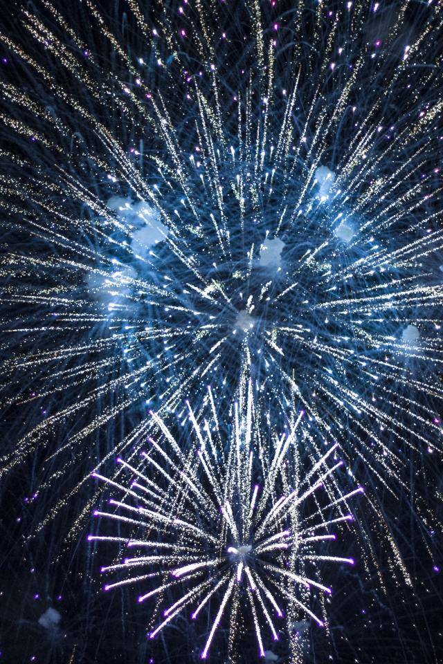 Яркие искры праздничного фейерверка  в ночном небе 