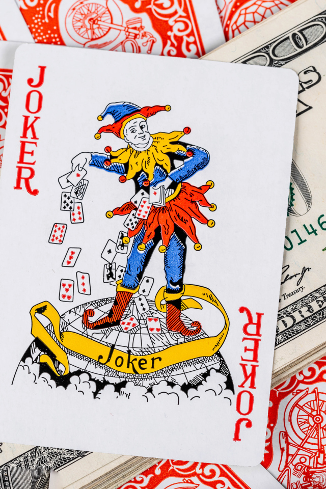 Card Joker and a pack of hundred-dollar bills