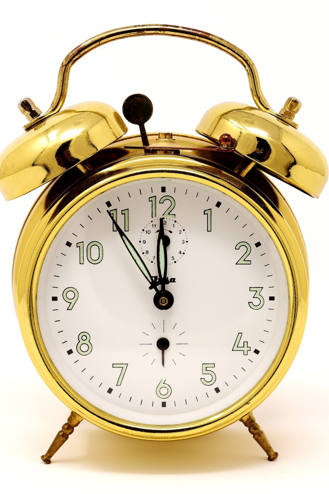 Золотой будильник на белом фоне 