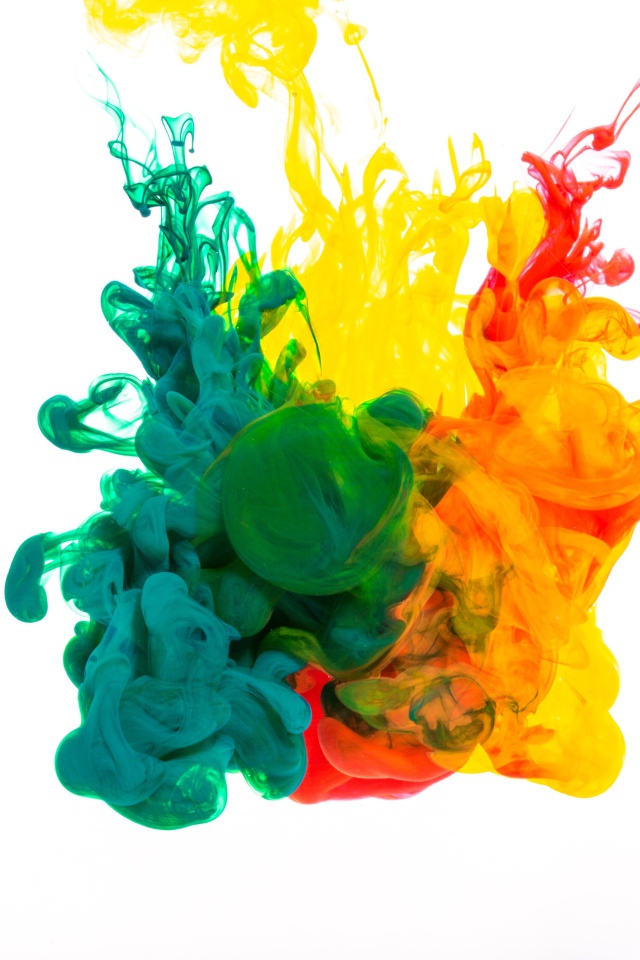 Зеленая и желтая краска растворяются в воде на белом фоне