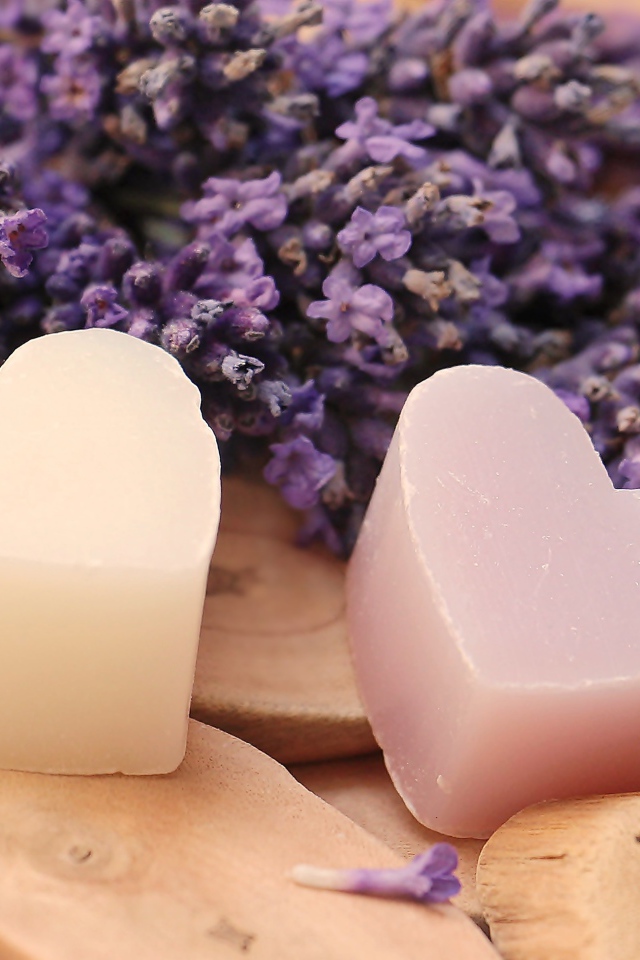 Мыло в форме сердца на столе с цветами лаванды