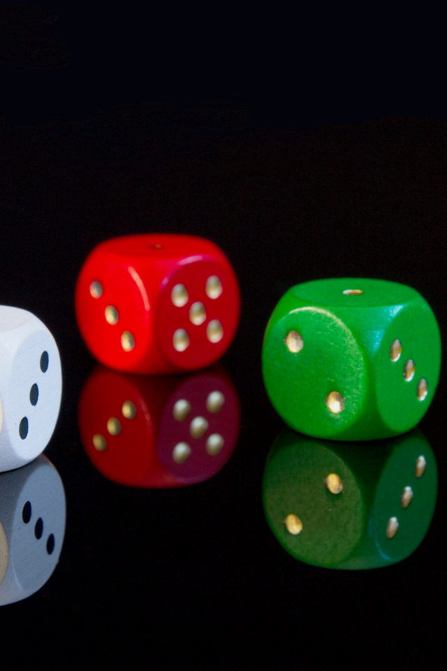 Разноцветные игральные кубики на черном фоне