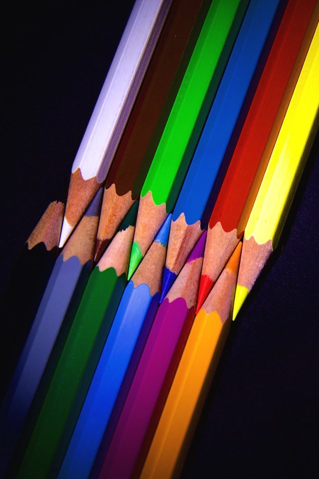 Разноцветные острые карандаши на черном фоне