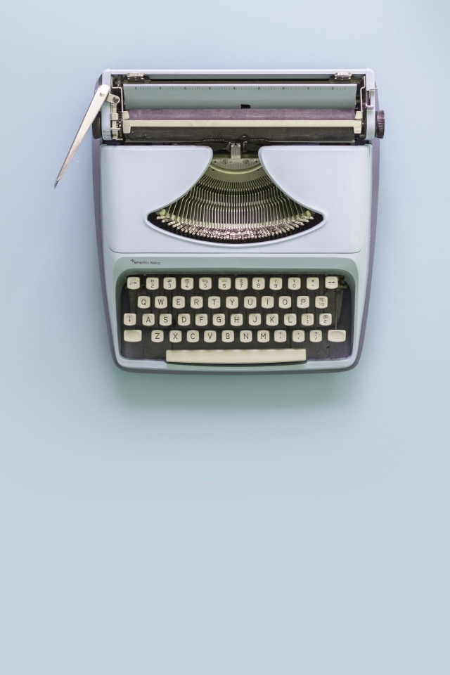 Старая печатная машинка на сером фоне 