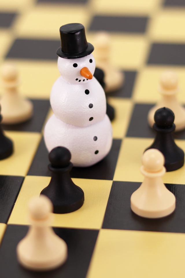 Фигурка снеговика на шахматной доске