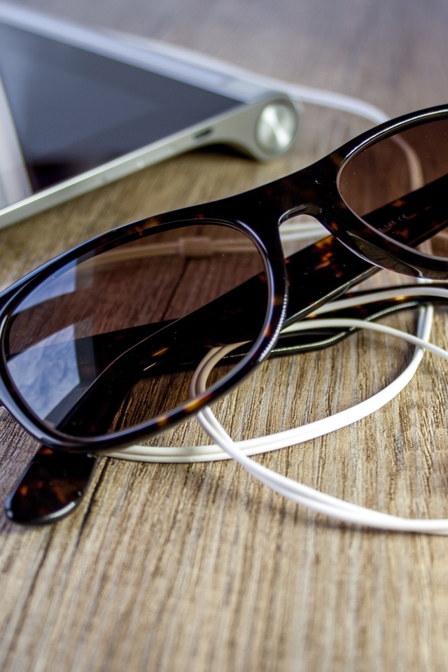 Солнечные очки с наушниками на столе