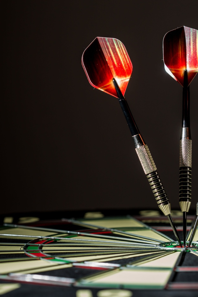 Три дротика в доске для дартс 