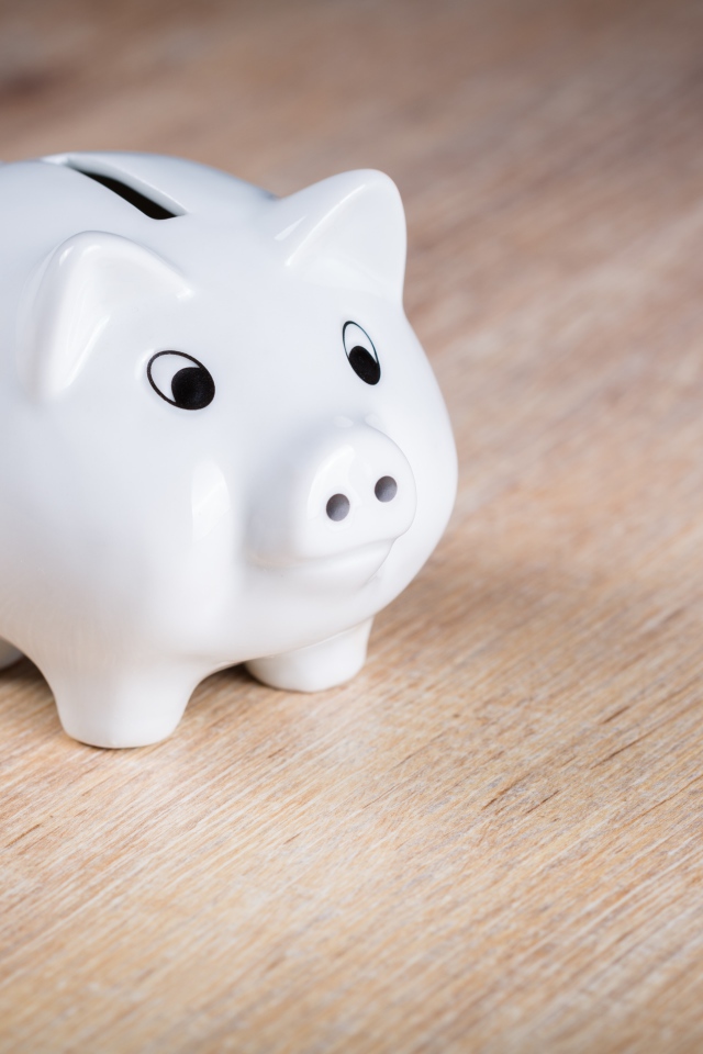 Белая свинья копилка на столе 