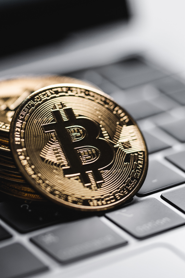 Монеты биткоин лежат на клавиатуре ноутбука 