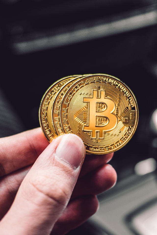 Две монеты биткоин в руке 