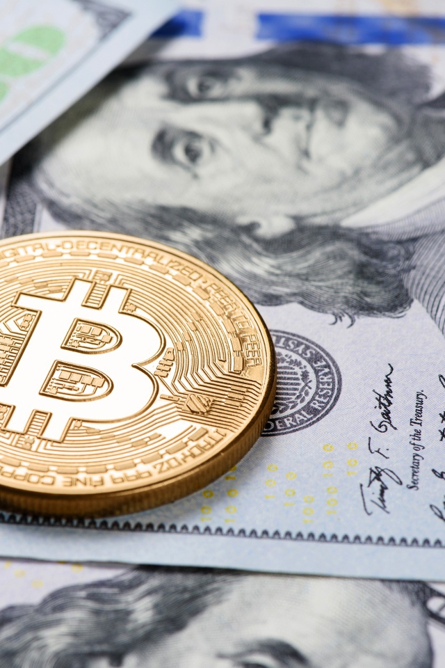 Bitcoin gold coin lies on dollars