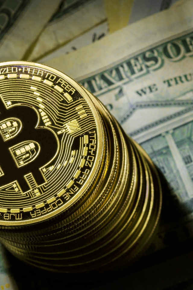 Золотые монеты биткоин лежат на долларах