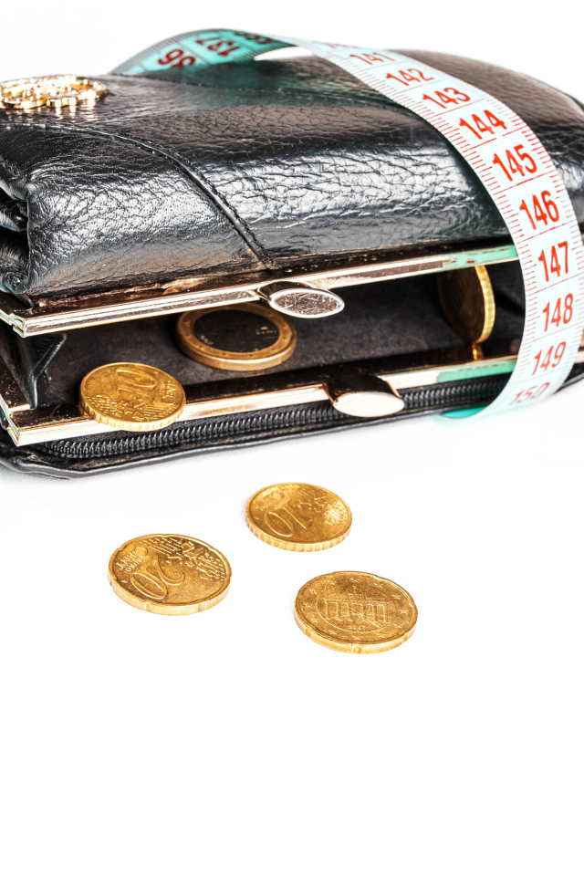 Черный кожаный кошелек с монетами и сантиметром на белом фоне