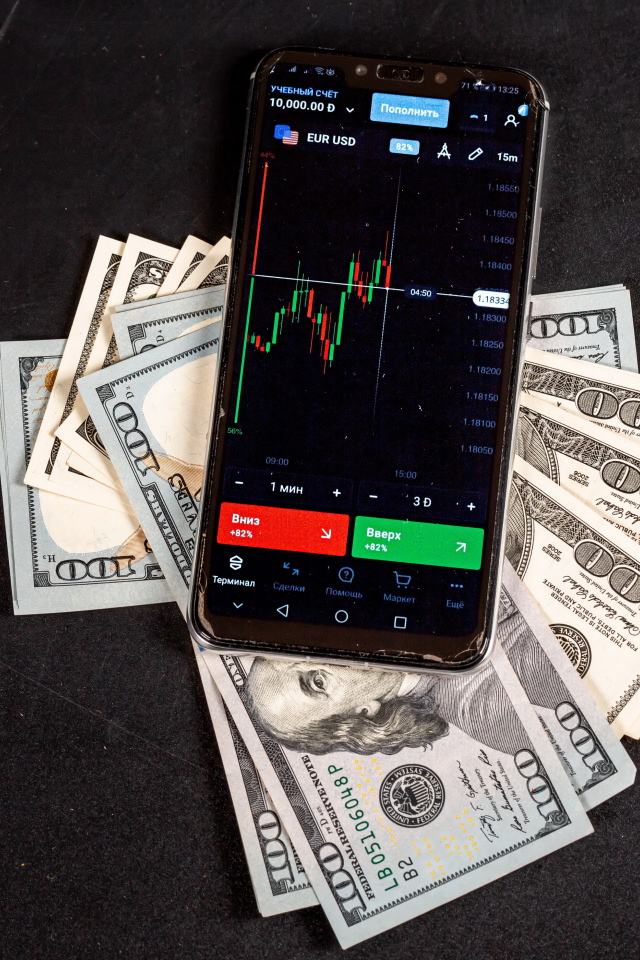 Доллары и смартфон на сером столе 