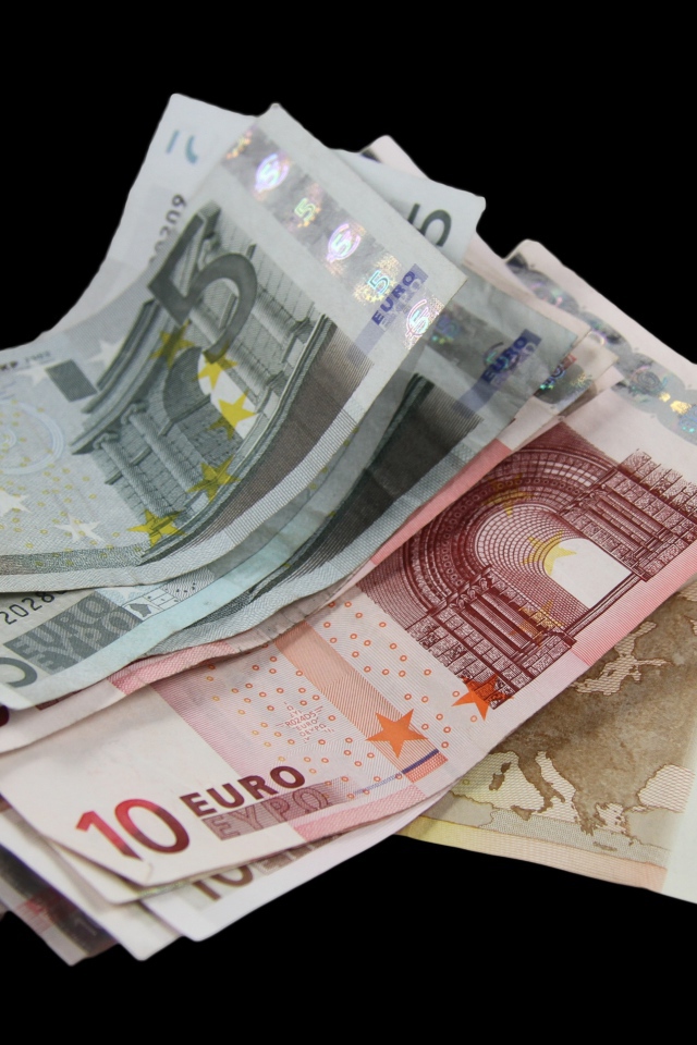 Много бумажных купюр евро на черном фоне