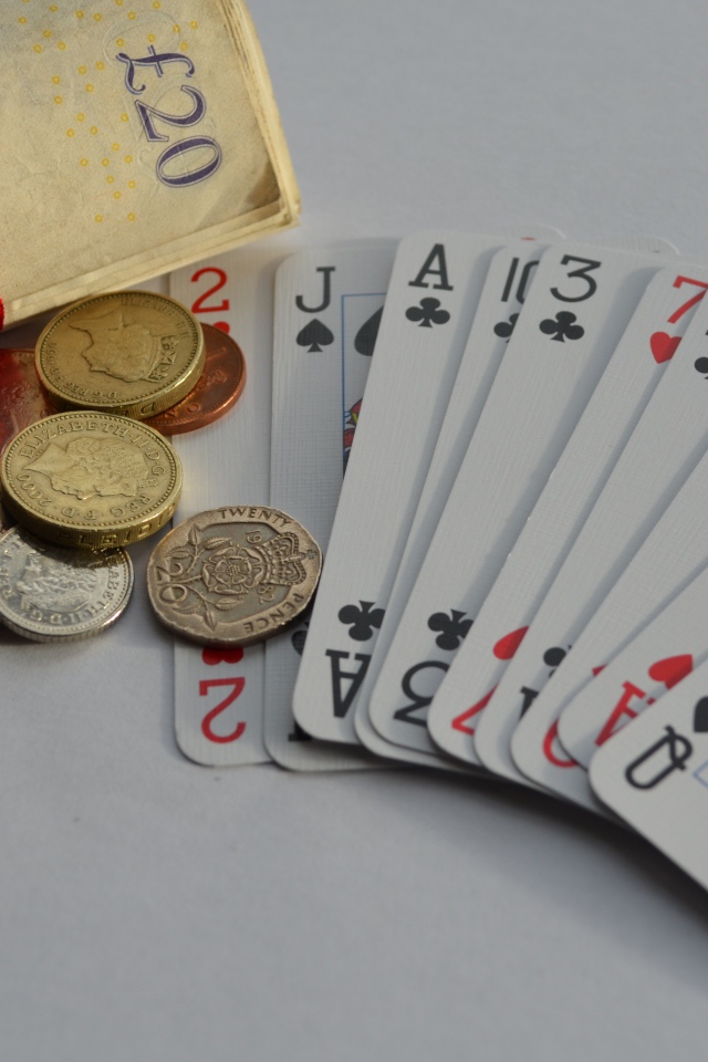 Деньги, монеты и колода карт на столе