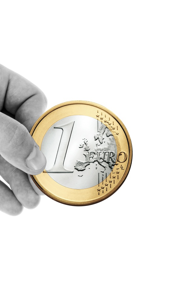 Монета в один евро в руке на белом фоне