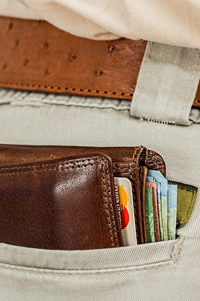 Кошелек с деньгами и карточками в кармане брюк 