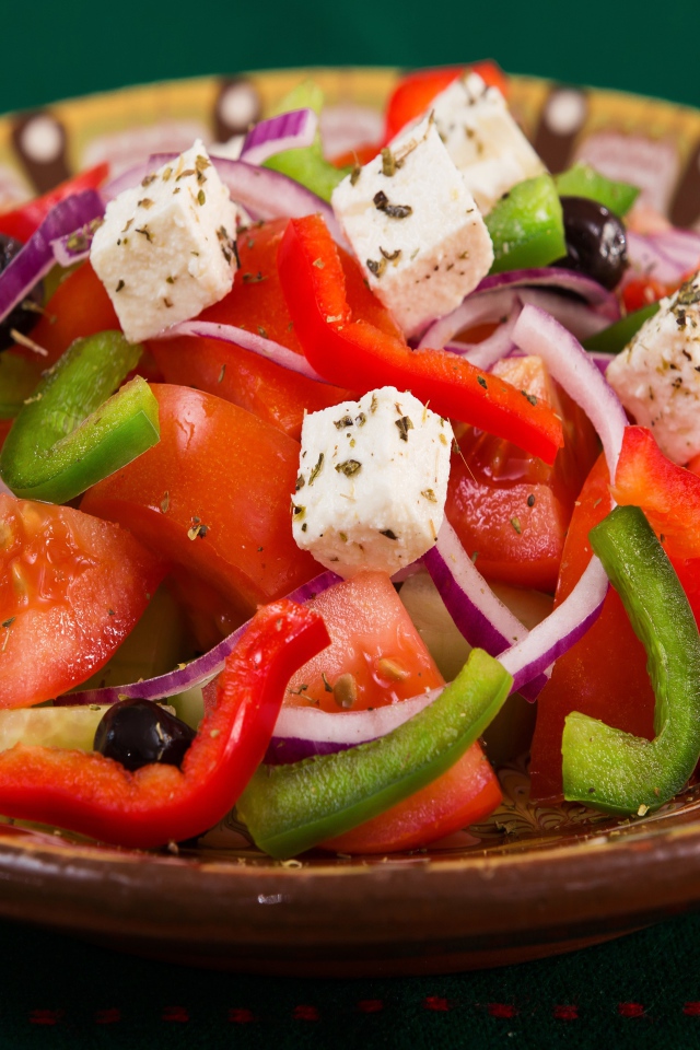 Аппетитный греческий салат в тарелке на столе