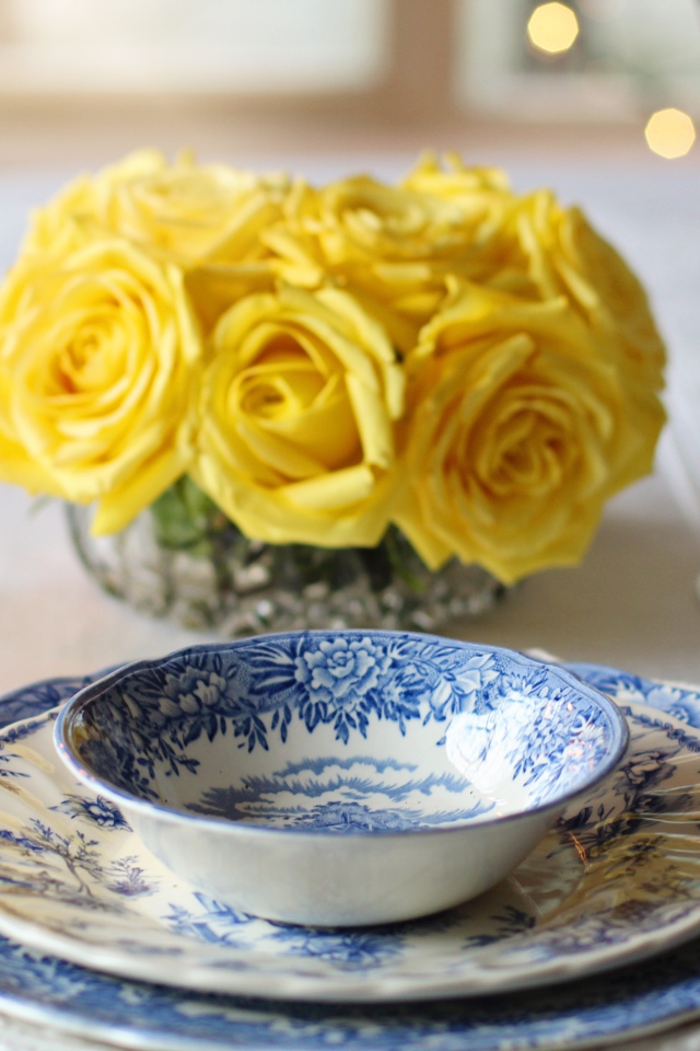 Красивая посуда на столе с букетом роз и свечами