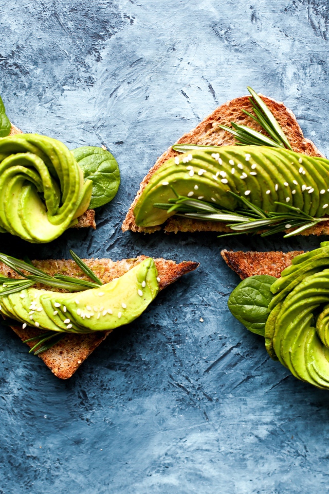 Хлеб с авокадо и базиликом на столе 