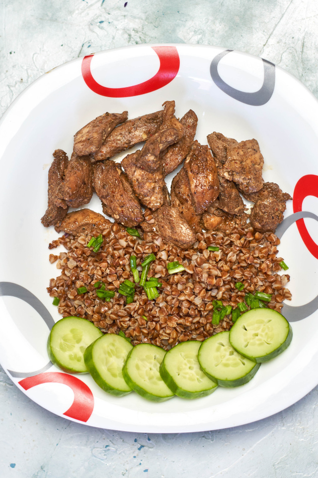 Гречка на тарелке с мясом и огурцами