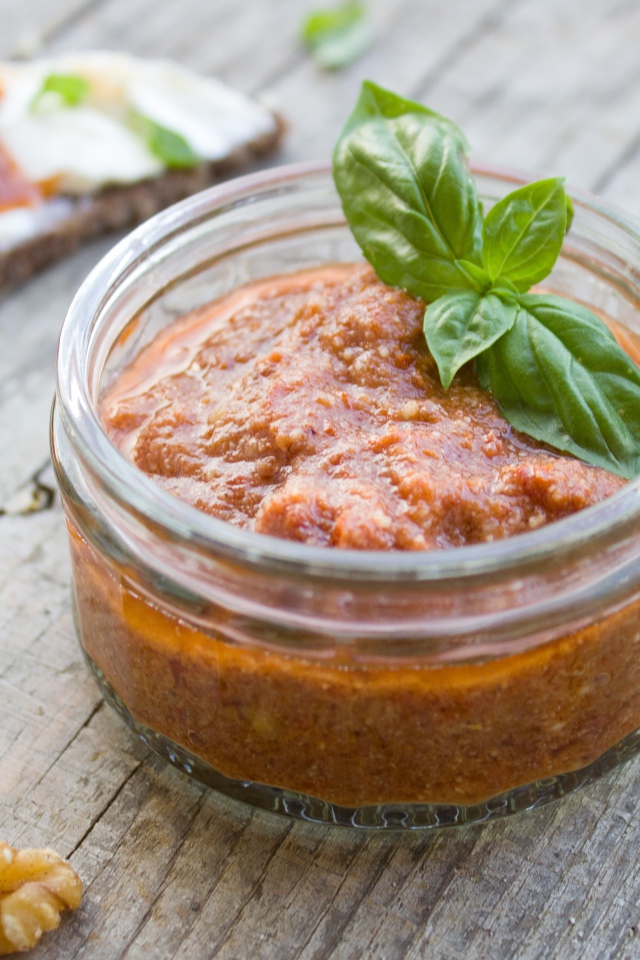 Икра в банке с базиликом на столе с орехами 