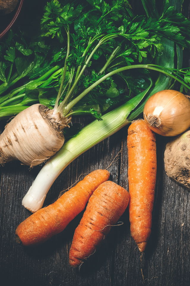 Сельдерей, морковь и лук на столе 