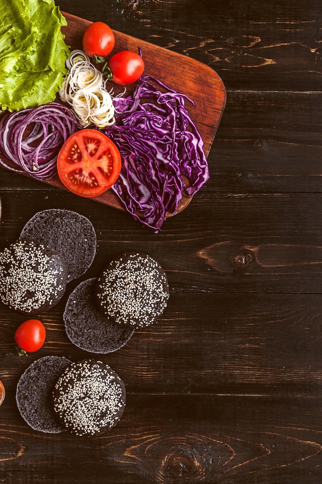 Повар готовит гамбургеры на деревянном столе