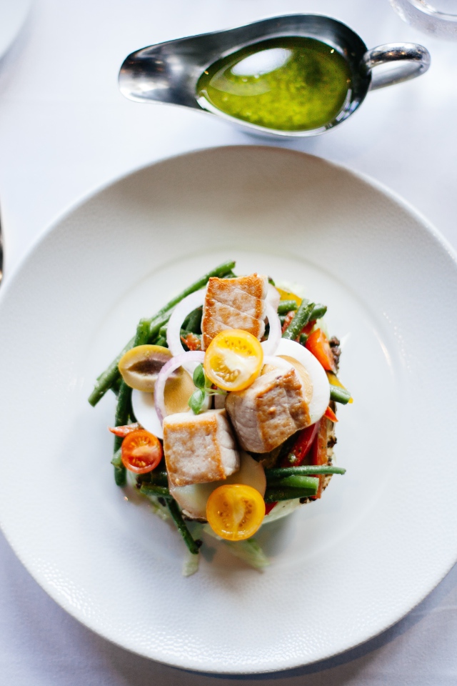 Салат из куриного филе с овощами на белой тарелке