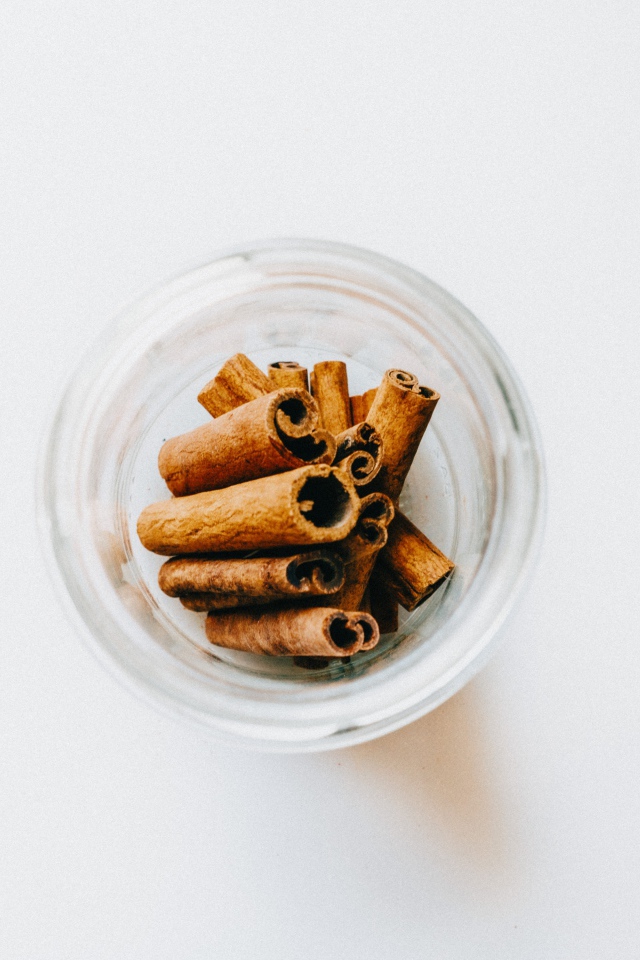 Корица в стеклянной банке на белом фоне 