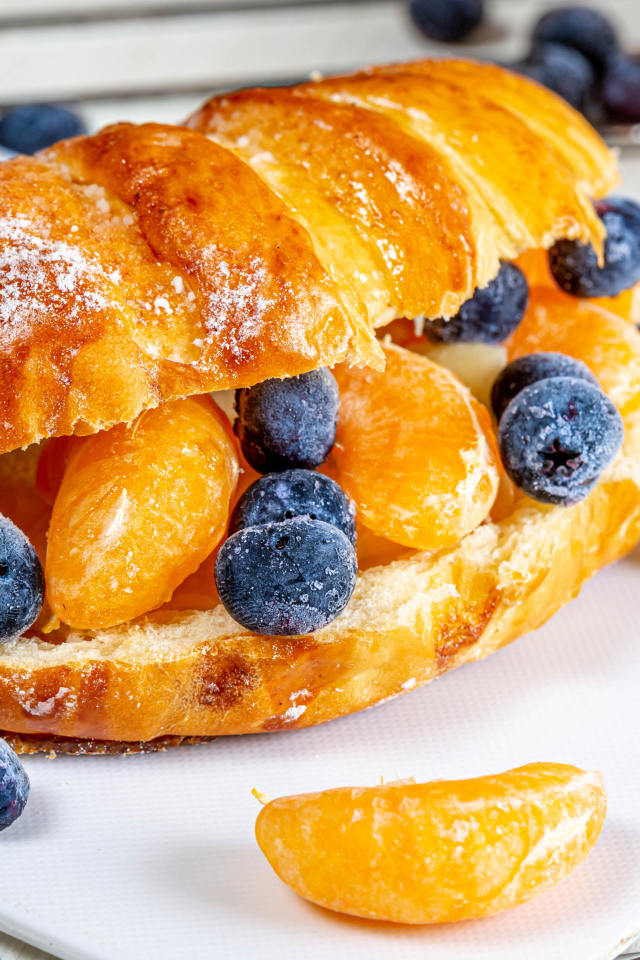 Круассан с дольками мандарина и черникой 