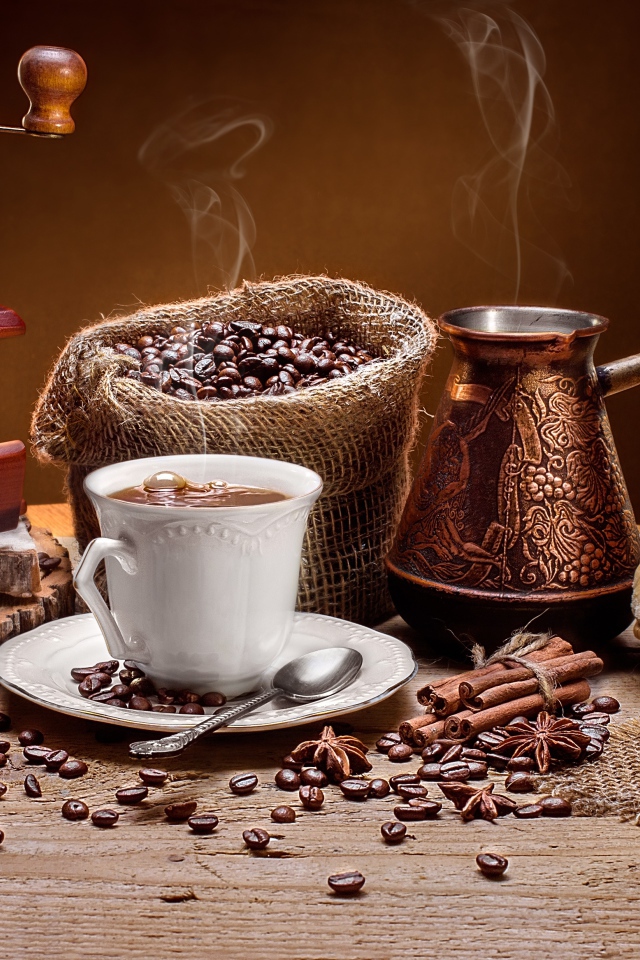 Чашка кофе на столе с круассанами и кофемолкой