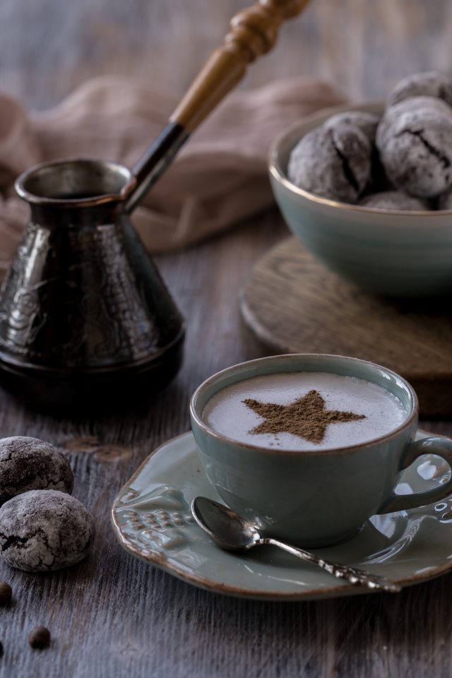 Чашка кофе на столе с пряниками и зернами