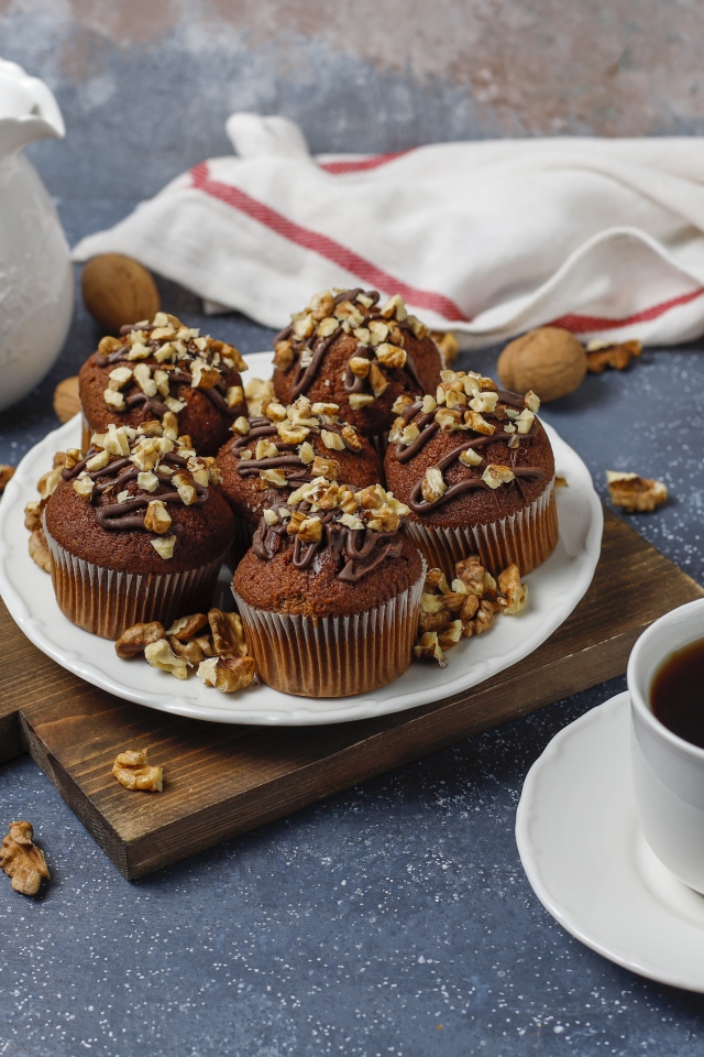 Вкусные шоколадные кексы с орехами на столе с кофе