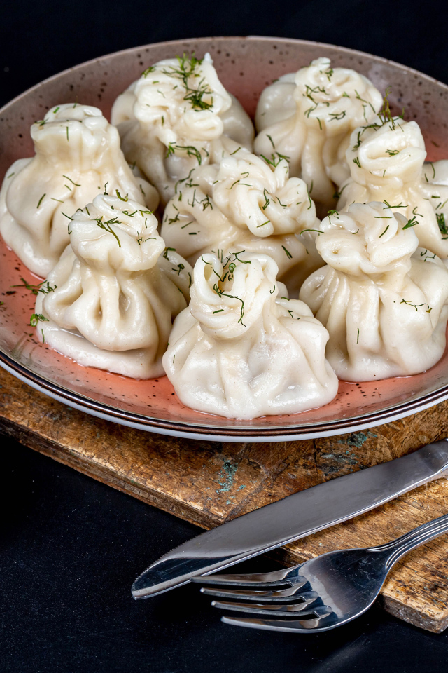 Вкусные горячие хинкали на столе с соусом