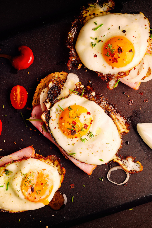 Fried eggs on sandwiches on a cutting board