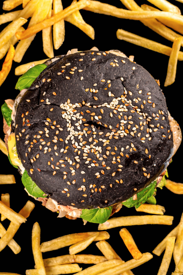 Гамбургер на черном фоне с картофелем фри