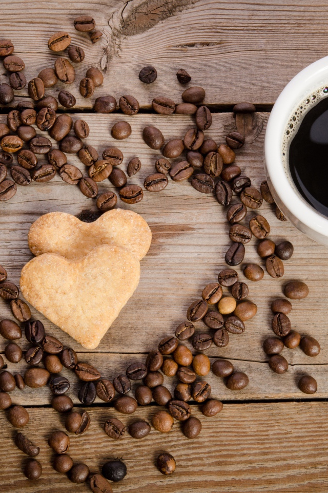 Печенье в форме сердца на столе с зернами и чашкой кофе 