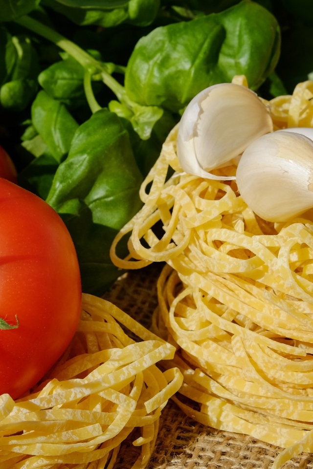 Домашняя лапша на столе с помидорами и базиликом