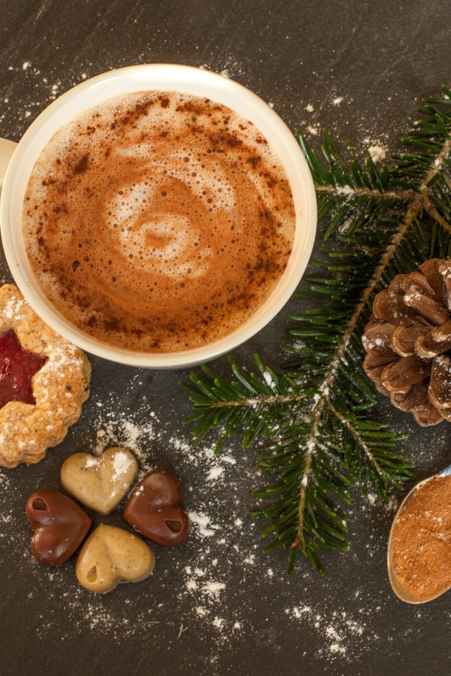 Горячий шоколад на столе веткой ели, печеньем и конфетами