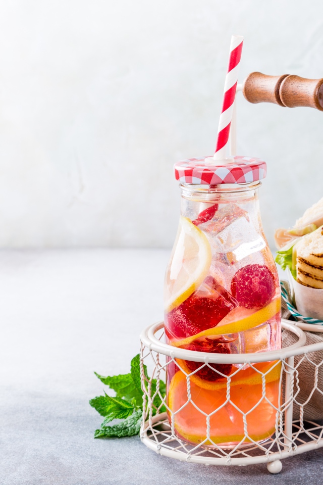 Банка с лимонадом в маленькой корзине с сэндвичем 