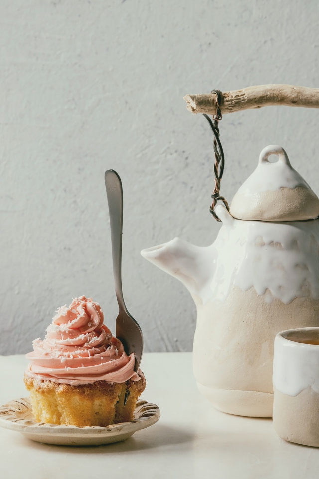 Чайник с чашкой на столе с кексом