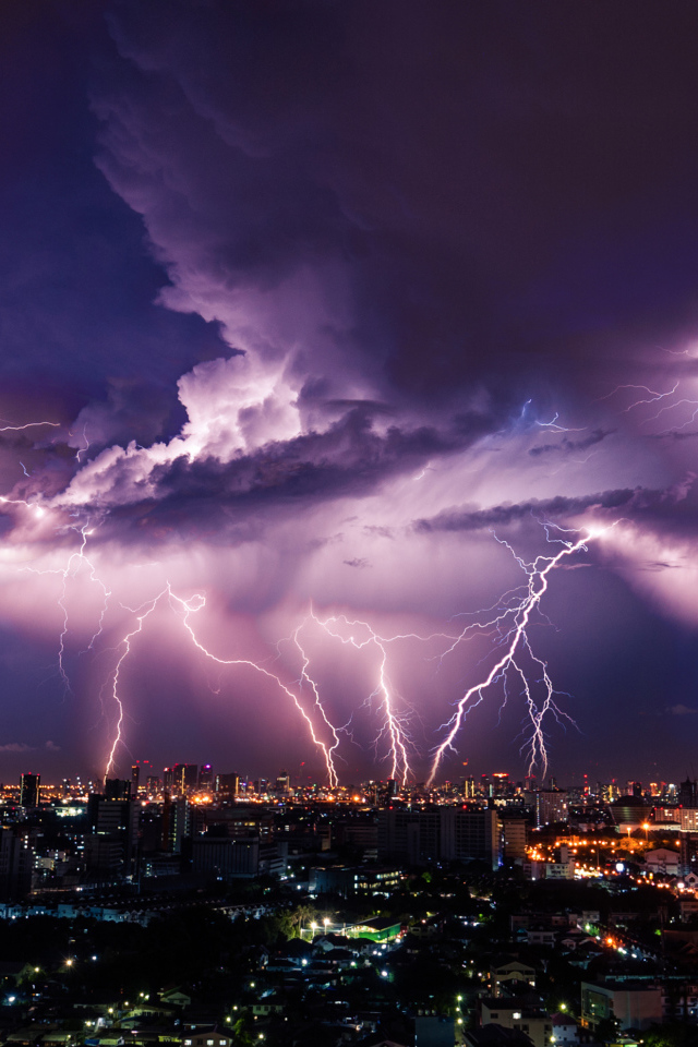 Молния пронзает грозовое небо над ночным городом